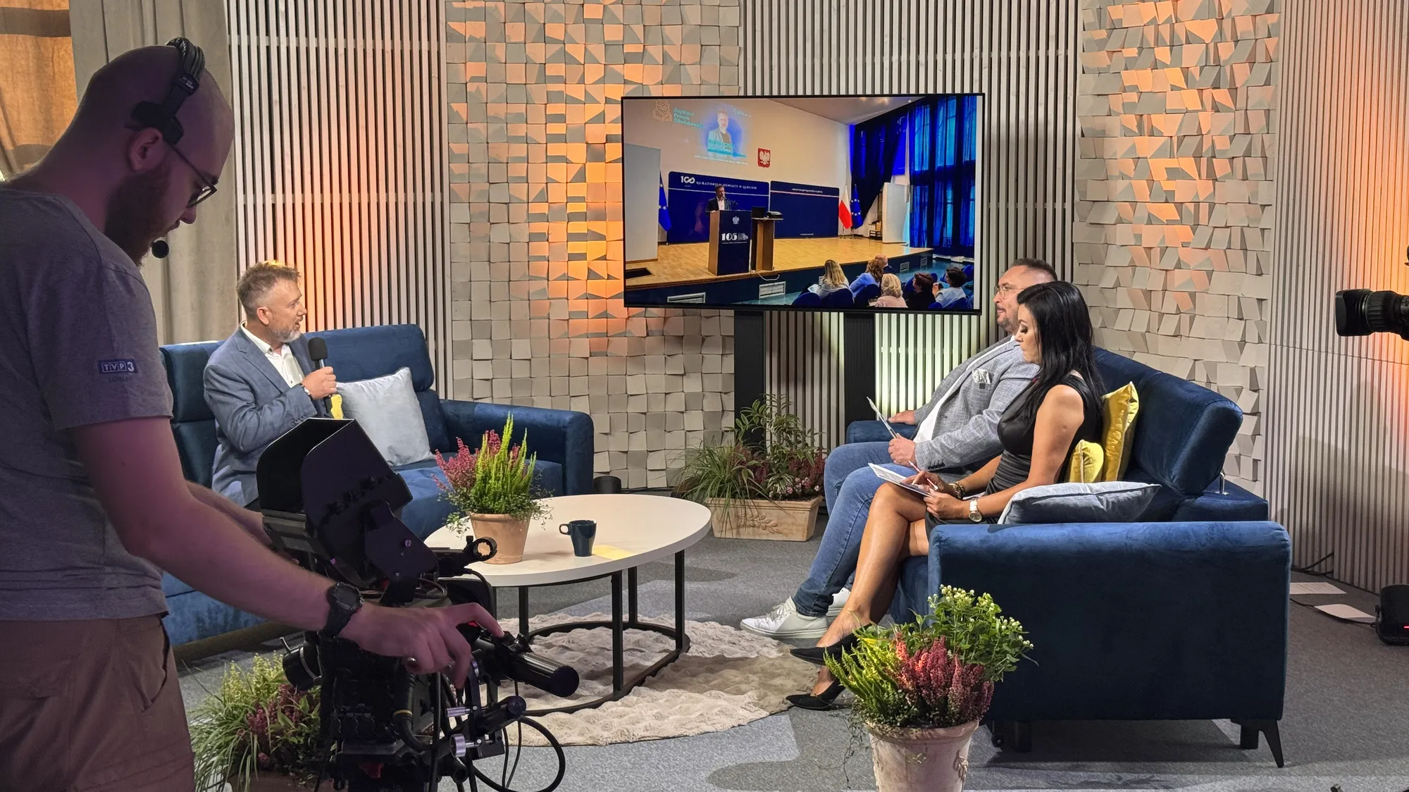 Plan zdjęciowy w studiu telewizyjnym — operator kamery podczas nagrania z udziałem Piotra Kruka
