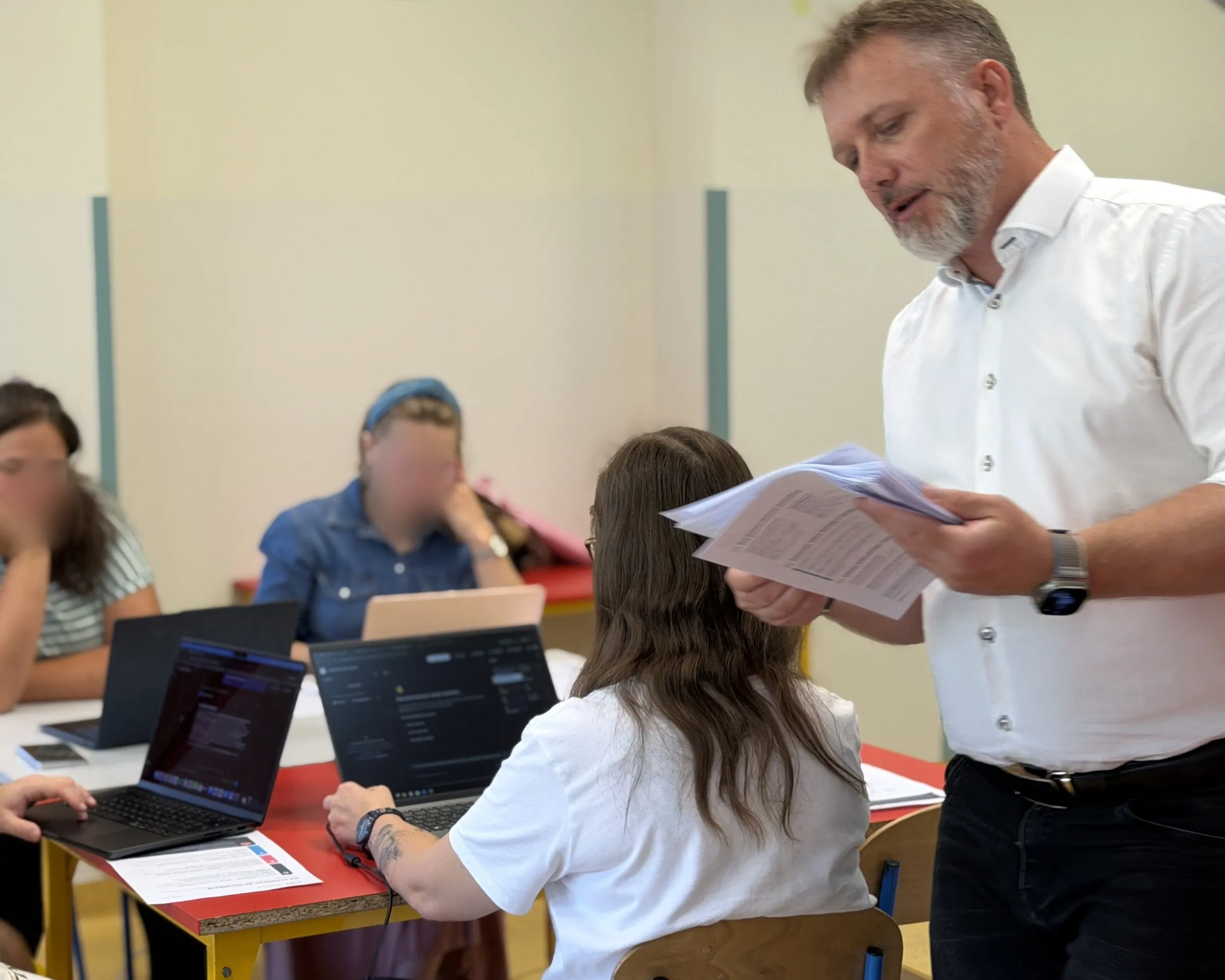 Piotr Kruk z dokumentem w ręku przy stanowiskach uczestników szkolenia